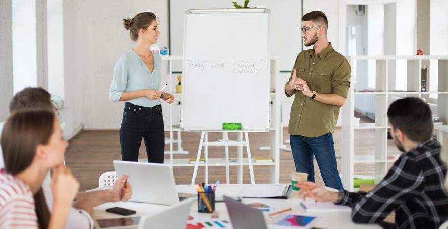 Une équipe de personnes travaillant ensemble dans un bureau, entourées d'ordinateurs et de paperasse