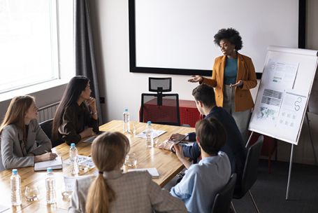Une femme présente son message à un public et captive son public par son discours et ses supports visuels