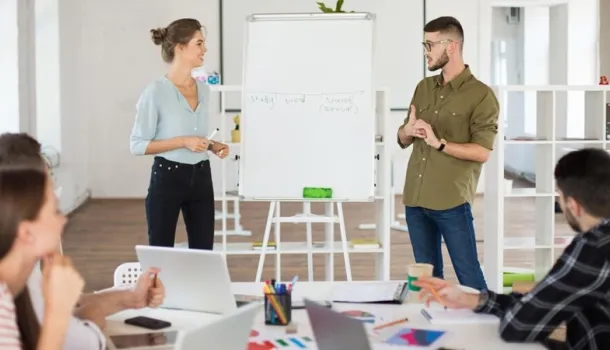 Une équipe de personnes travaillant ensemble dans un bureau, entourées d'ordinateurs et de paperasse