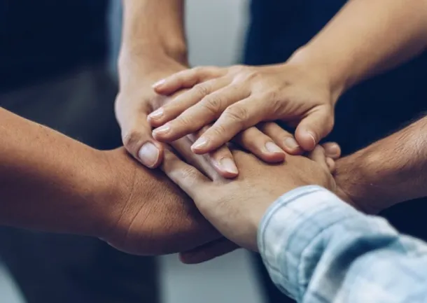 cinq mains l'une sur l'autre symbolisant l'accompagnement