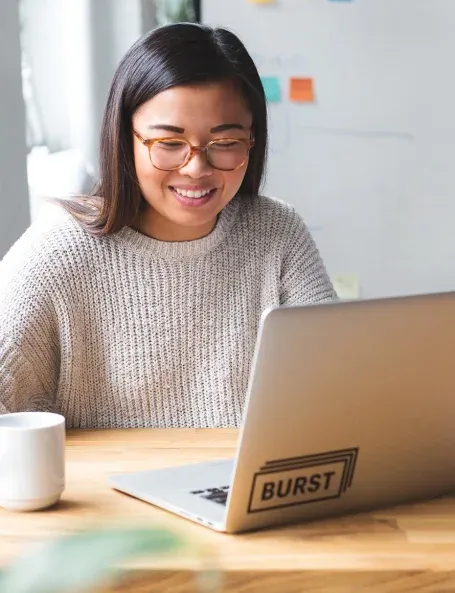 Une femme joyeuse, travaillant sur son ordinateur portable